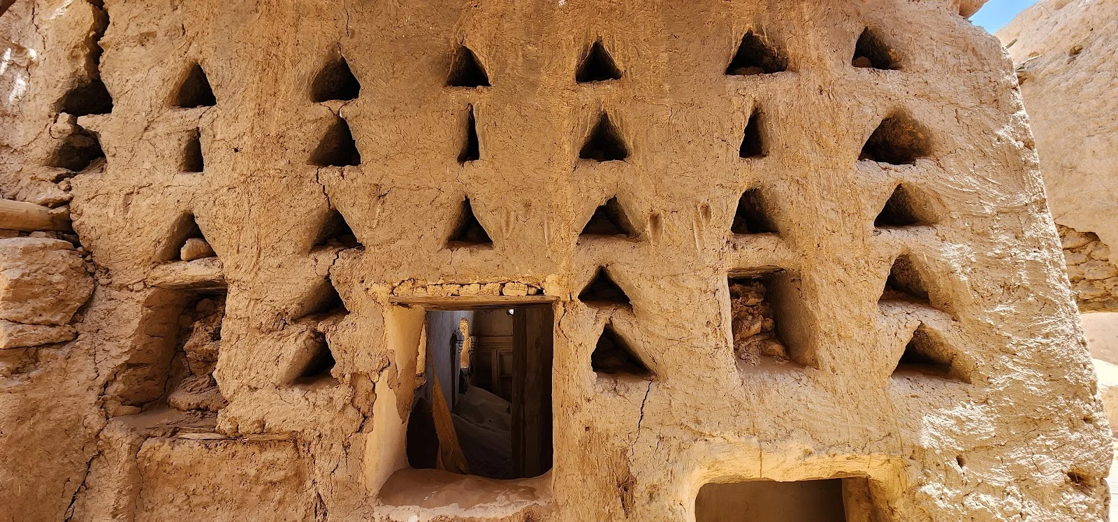 الزخرفة الهندسية النجدية على جدار طيني؛ تفصيل صغير يحفظ ذوق المكان وذاكرته كما يقول المقال. المصدر: «زخارف نجدية على جدار في قرية العمار التراثية» — تصوير فارس الفهيد، 2024م، Wikimedia Commons، رخصة CC0 · https://commons.wikimedia.org/wiki/File%3AAl-Ammar_village_Najdi_decorations.webp